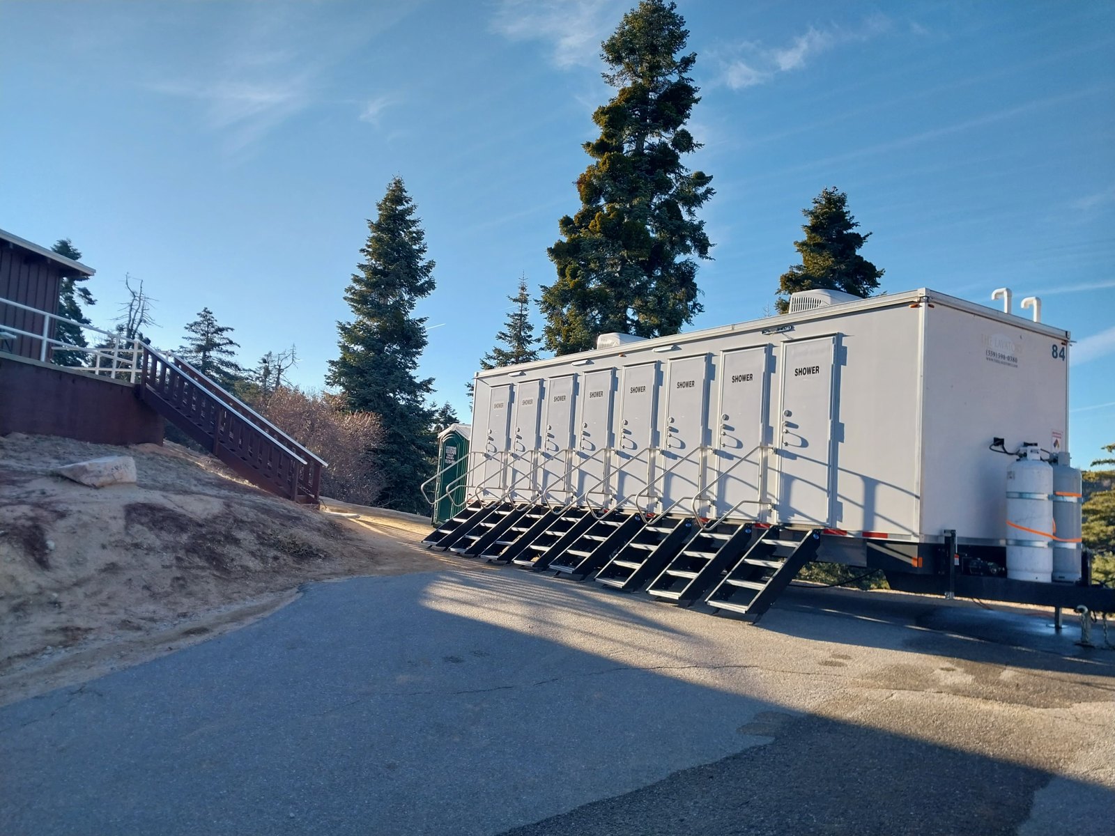 Mobile shower trailer being delivered and leveled on a gravel site in Colorado