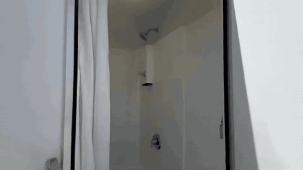 Animated walkthrough inside a multi stall shower trailer showing tiled stalls, a vanity and interior lighting